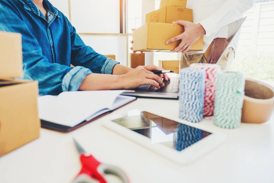 Dos personas gestionando pedidos y cajas en un depósito, representando los desafíos operativos que pueden llevar al agotamiento de stock en e-commerce