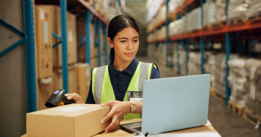 Trabajadora de almacén escaneando paquetes con laptop en gestión logística para vender en Walmart Marketplace 