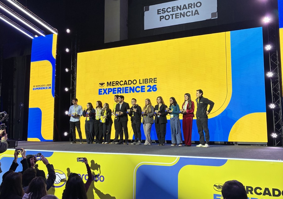 Grupo de personas en el escenario Potencia del Meli XP 2026 con el logo de Mercado Libre Experience 26 al fondo. 