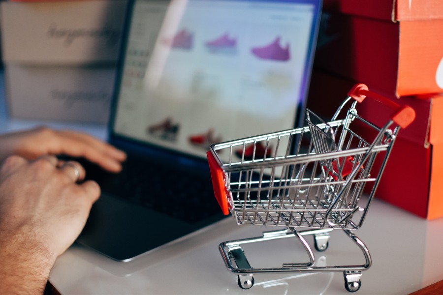Persona comprando zapatillas online con carrito de compras, símbolo de la integración de marketplaces en e-commerce 